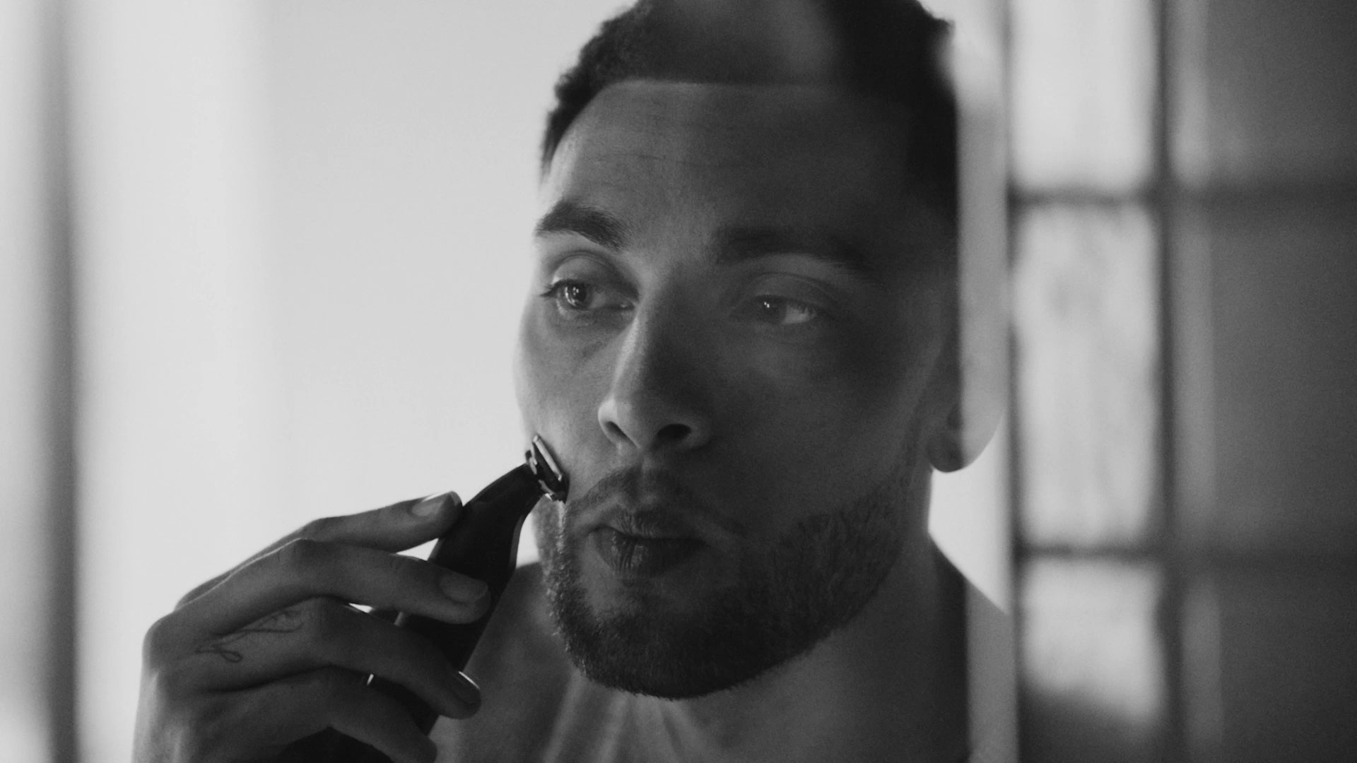 Black and white photo of NBA Bulls player Zach Lavine shaving his face with a Gillette razor in the mirror.