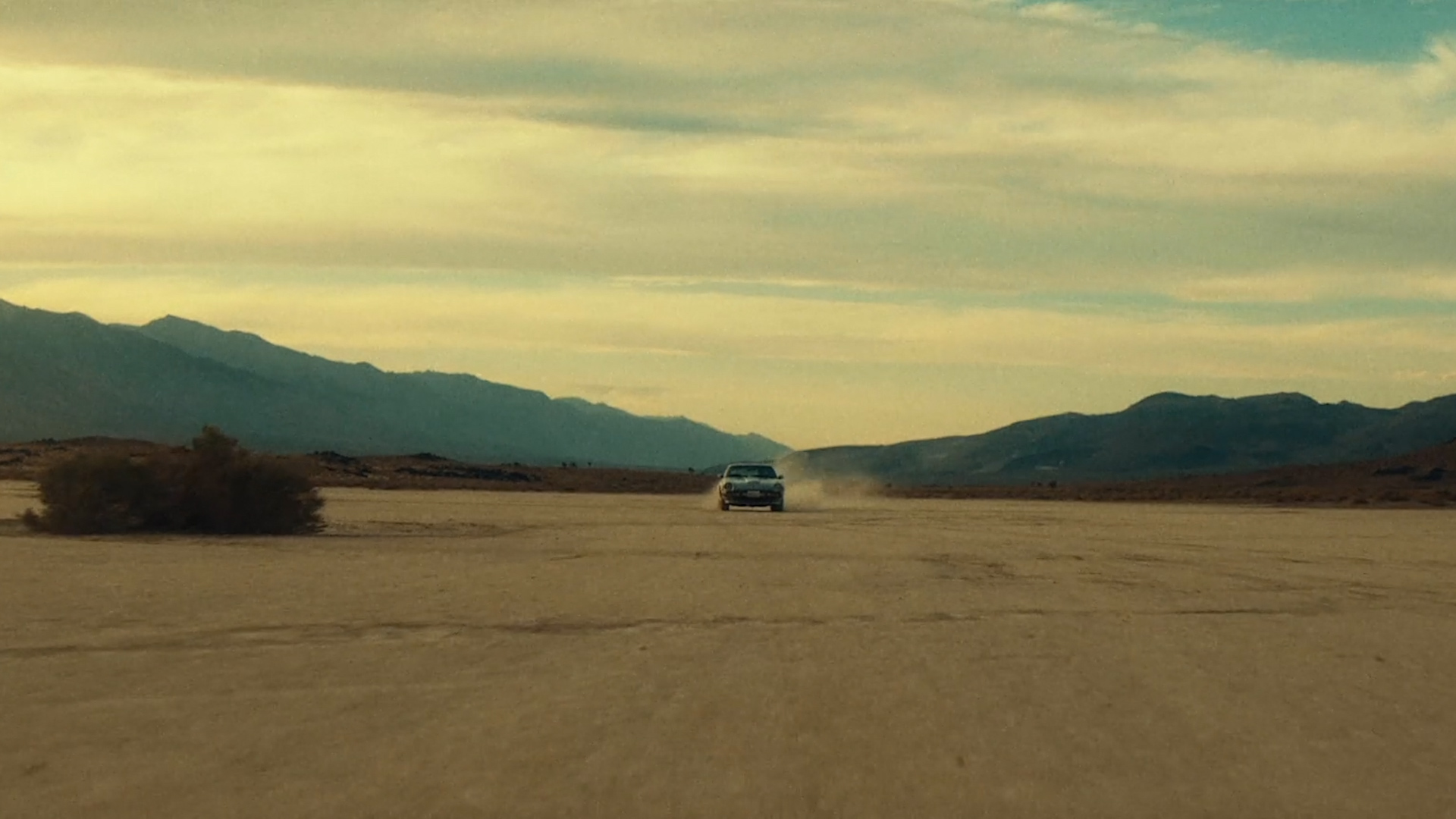 A car drives through the desert.