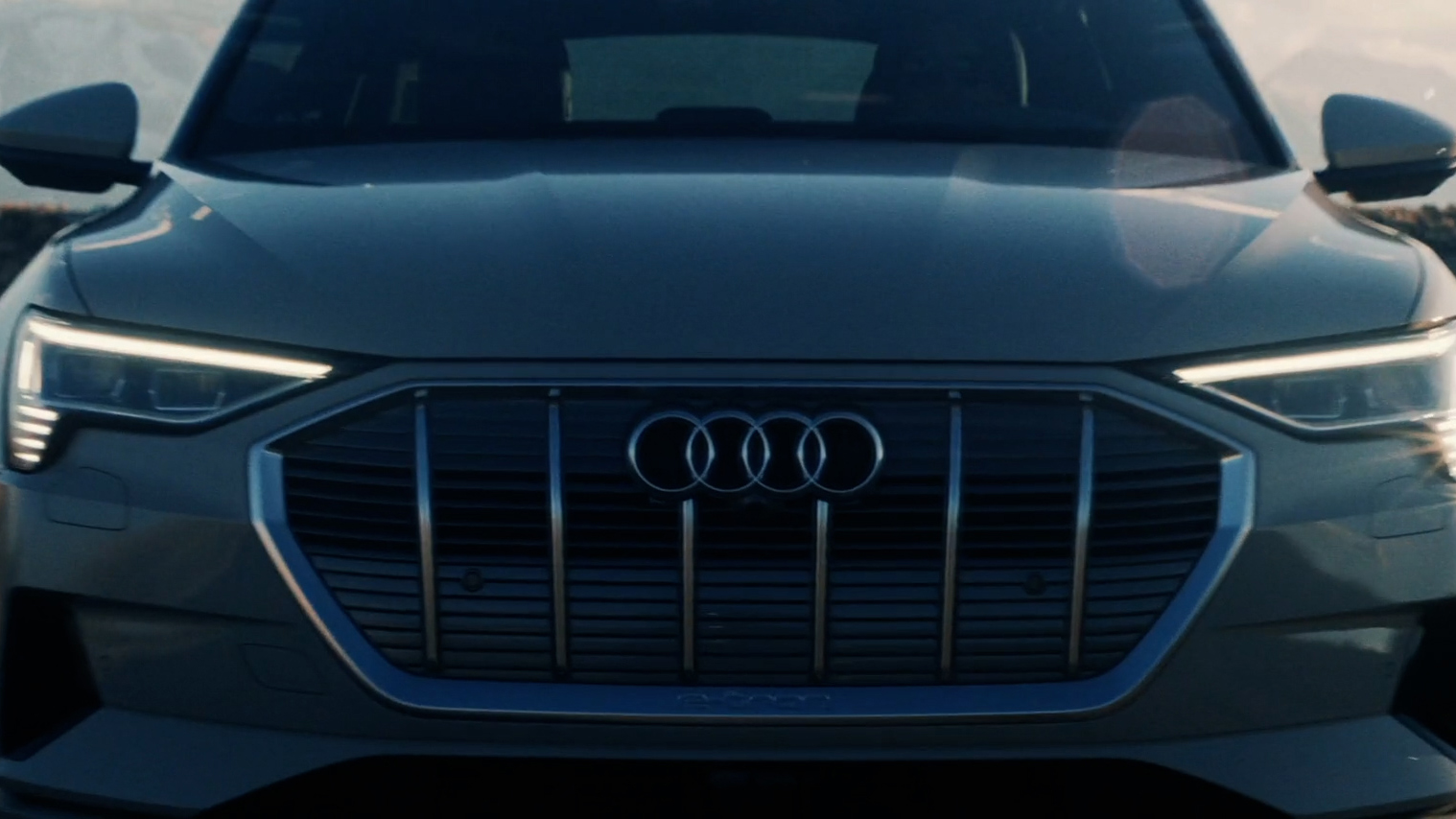 A close-up of an Audi sedan's front grille with daytime running lights on.