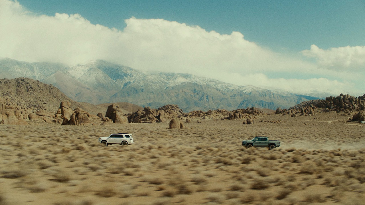 A desert landscape with two cars.