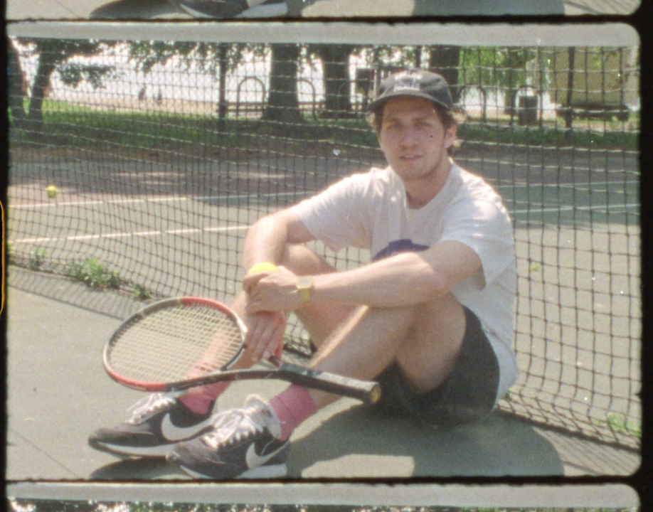 A man sitting at the tennis court.
